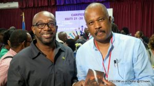 Sir Hilary Beckles (R), UWI Vice Chancellor and Chairman of CARICOM Reparations Commission, receives a copy of The Essence of Reparations by Amiri Baraka (HNP), from Shujah Reiph. Beckles was a guest speaker at the CARIFESTA XII symposium, “The Caribbean, A Collective Memory.” Haiti, 2015.  (© CLF photo)